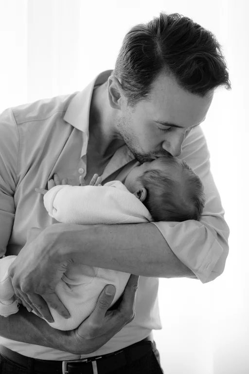 Neugeborenenfotografie in ruhiger Atmosphäre, reduziert und ästhetisch in Berlin Brandenburg, Papa mit Baby im Arm